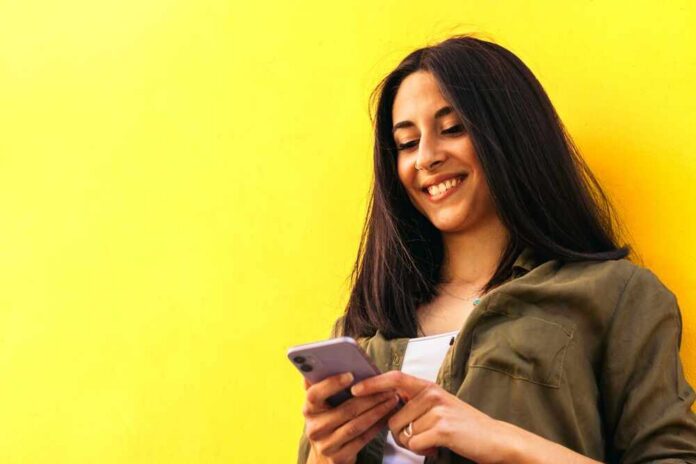 Young,Stylish,Woman,Smiling,Typing,Something,With,The,Mobile.,Leaning