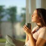 Woman enjoying a cup of coffee in a sunlit room