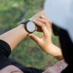 Person adjusting a smartwatch on their wrist outdoors