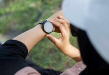 Person adjusting a smartwatch on their wrist outdoors