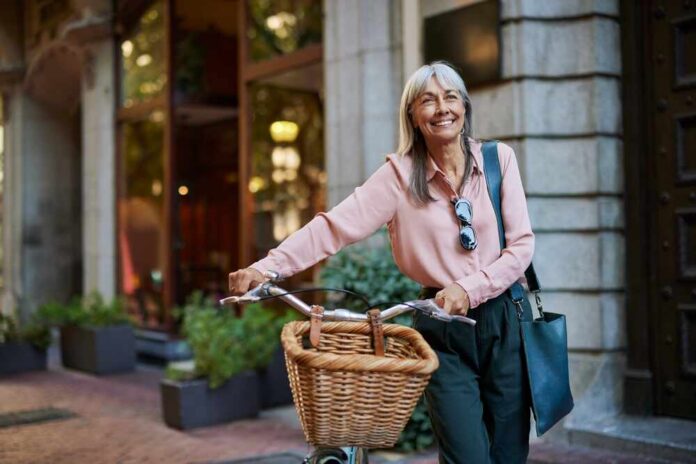 Happy,Senior,Woman,In,Casual,Smiling,While,Holding,Her,Bicycle.