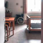 View of a hospital room featuring a patient bed and a wheelchair