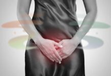 Woman in a black dress holding her stomach, indicating discomfort