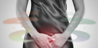 Woman in a black dress holding her stomach, indicating discomfort