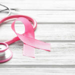 Rare Cancer’s Hidden Identity Theft A pink ribbon next to a stethoscope on a wooden surface