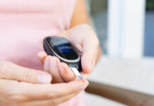 Person using a blood glucose meter to check their blood sugar level