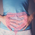 Gut Bacteria’s Shocking Role in IBS Relief Person holding their stomach with a graphic of intestines overlayed