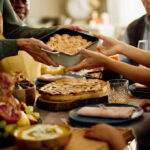 A family sharing a dish during a festive meal