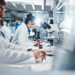Scientists working in a laboratory with microscopes and test tubes