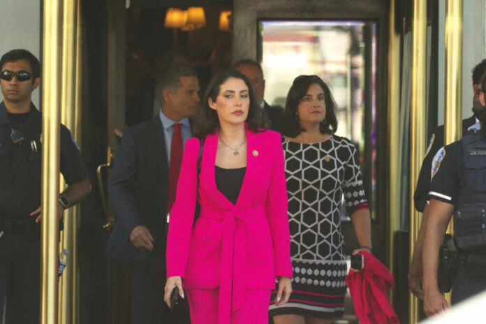 A group of women in professional attire exiting a building with security personnel