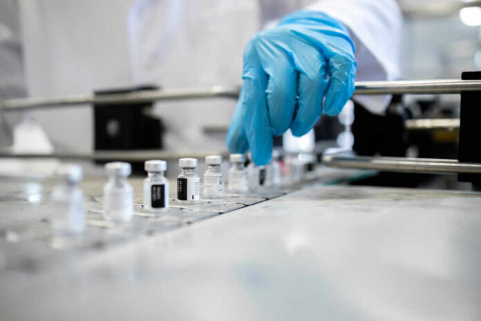 shutterstock2116117133jpg-1 A healthcare professional in a lab preparing vaccine vials