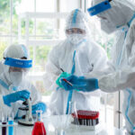Cancer Vaccines: The Next Big Thing? Scientists in protective suits conducting research in a laboratory