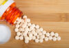 Heart Study UNCOVERS Antidepressant Risks Spilled white pills from a prescription bottle on a wooden surface
