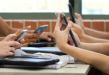 Doomscrolling: Why You Can’t Stop Students in a classroom using smartphones for a group activity