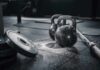 Gym vs. Everyday Movement Kettlebells and weights on a gym floor with chalk dust