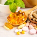Assorted vitamins and supplements arranged with mint leaves