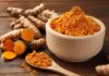 Turmeric’s True Benefits: What Science Says Turmeric powder in a wooden bowl with fresh turmeric roots