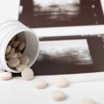 Spilled pills beside medical imaging prints