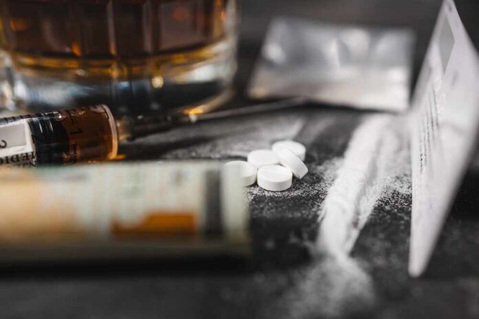 White,Narcotic,Pills,,An,Alcoholic,Drink,In,A,Glass,,A A close-up of a syringe, pills, and a glass of alcohol on a dark surface
