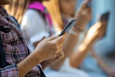 2682720135 Hands of young people using smartphones
