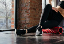 Person using a foam roller for stretching in a fitness studio