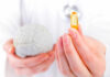 Brain Supplement Tied To Shorter Lifespan A medical professional holding a brain model in one hand and a yellow supplement capsule in the other