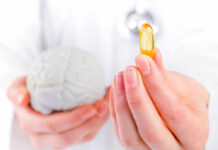 Brain Supplement Tied To Shorter Lifespan A medical professional holding a brain model in one hand and a yellow supplement capsule in the other