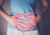 Scientists Develop a Fart Chart to Measure Gut Health Person holding their stomach with a graphic of intestines overlayed