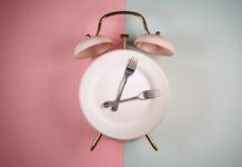 Fasting Backfires After 60 An alarm clock with a plate and two forks arranged in a creative design