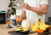 Removing the “Chalky” Taste from your Protein Shake Person preparing a protein shake with fruits and whey protein powder in a kitchen