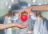Chemotherapy: Types and How They Really Work Two hands exchanging a red heart symbol in a surgical setting
