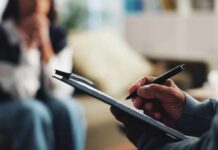 Depression Mystery: Why Women Crash Harder A therapist taking notes during a session with a client in the background