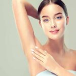 Woman touching smooth underarm with raised arm