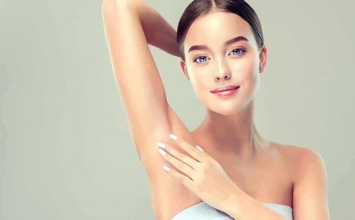 shutterstock_1028509384 Woman touching smooth underarm with raised arm
