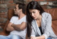How Toxic Love Slowly Rewires Your Brain woman looking down while man sits with arms crossed on couch