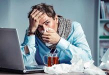 Double Flu Shock, Same Season: Why Immunity Fails Sick man at desk blowing his nose