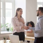 coworkers shaking hands in a bright office