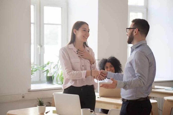 coworkers shaking hands in a bright office