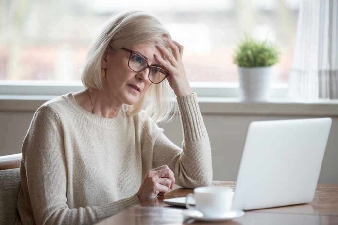 shutterstock_1185179209 Older woman with glasses looking concerned at laptop