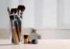 Clinic-Level Bacteria On Skincare Tools A collection of makeup brushes in a glass container on a table