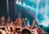 Crowd at a concert with hands raised in excitement