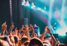 Festival ER: Inside the Music Festival Medical Tent Crowd at a concert with hands raised in excitement