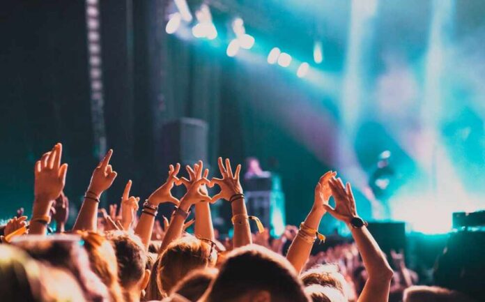 Crowd at a concert with hands raised in excitement