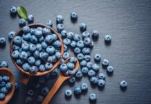 Blueberries vs. Grapes: Which Is Better for Heart Health? A bowl of fresh blueberries on a dark surface