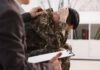 Global Mental Health Crisis—Crazy Numbers! Soldier in camouflage sits with head in hands during counseling session