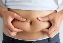 person pinching belly fat at the waist