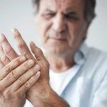 Man holding his hand in discomfort