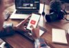 Attention Residue Is Taxing Brainpower Hands holding smartphone with video app icon at a workspace