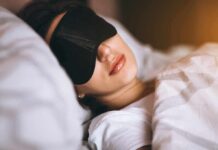Aging Spike From ‘Perfect’ Sleep? Woman sleeping with a black eye mask in bed