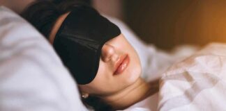 Woman sleeping with a black eye mask in bed
